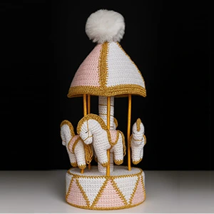 Carrossel de amigurumi decorativo nas cores rosa, branco e dourado