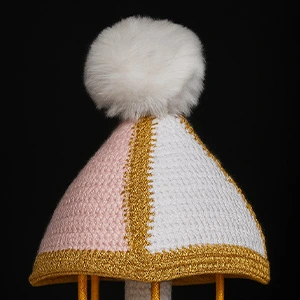 Topo do carrossel de amigurumi com pompom branco e detalhes dourados