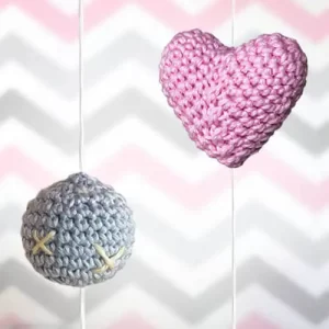 Esfera cinza e coração rosa feitos em amigurumi